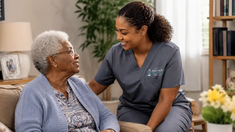 An Anchor Haven caregiver leaning in to talk with an older woman at home, both of them smiling.